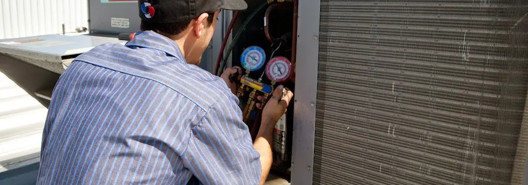 HVAC technician servicing a condenser unit in Anaconda-Deer Lodge County