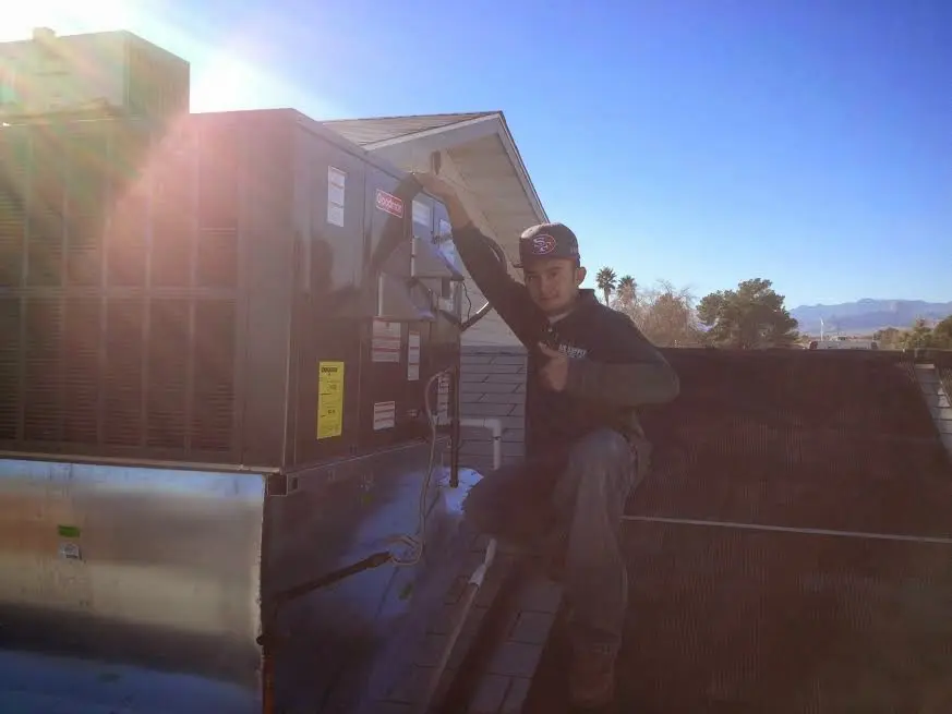 HVAC technician performing AC Tune-Up on a rooftop unit in Anaconda-Deer Lodge County